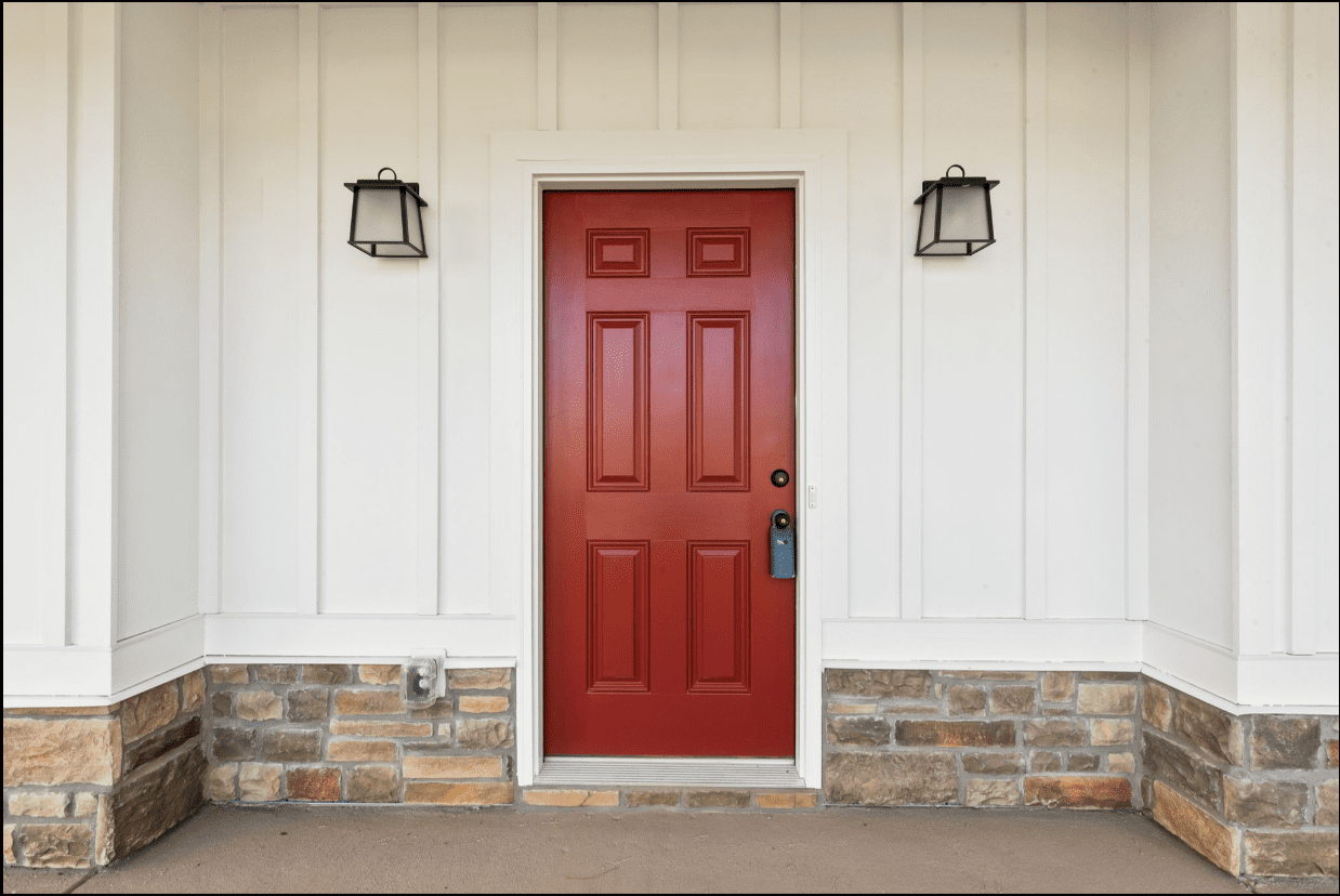 Red front door on white siding.
