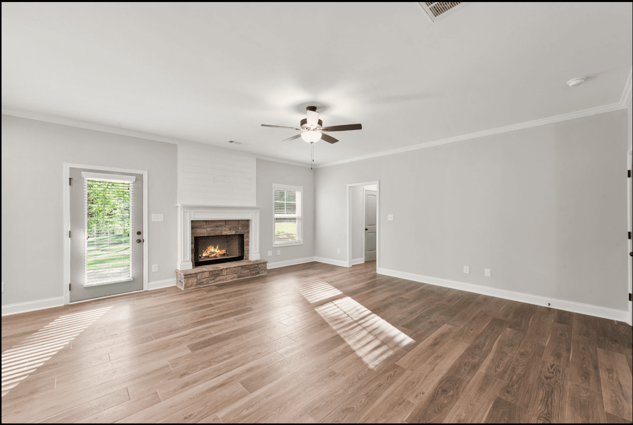 Spacious living room with fireplace and hardwood floors.