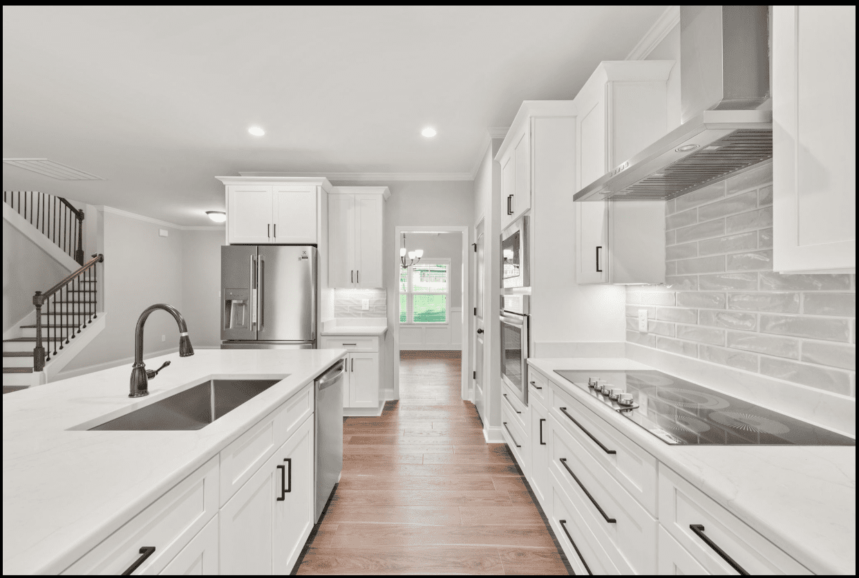 Modern white kitchen with stainless appliances.