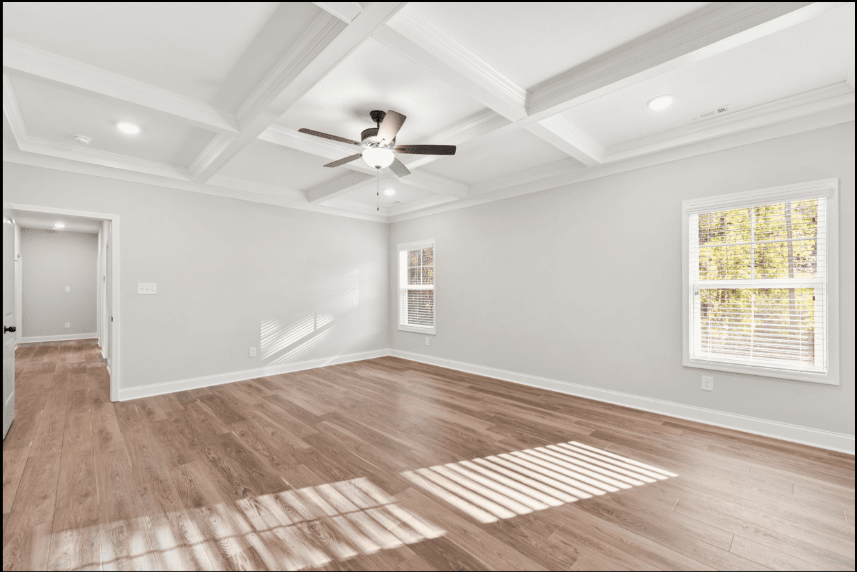 Spacious room with hardwood floors and coffered ceiling.