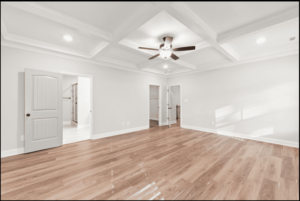 Spacious bedroom with hardwood floors and ceiling fan.