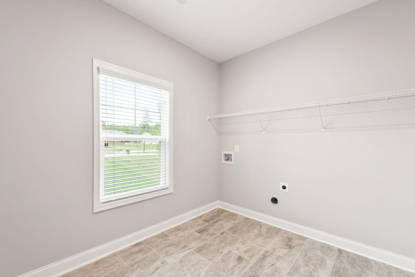 Laundry room with window and shelving.