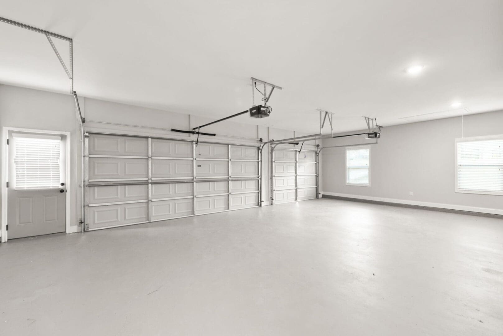 Empty three-car garage with automatic doors.