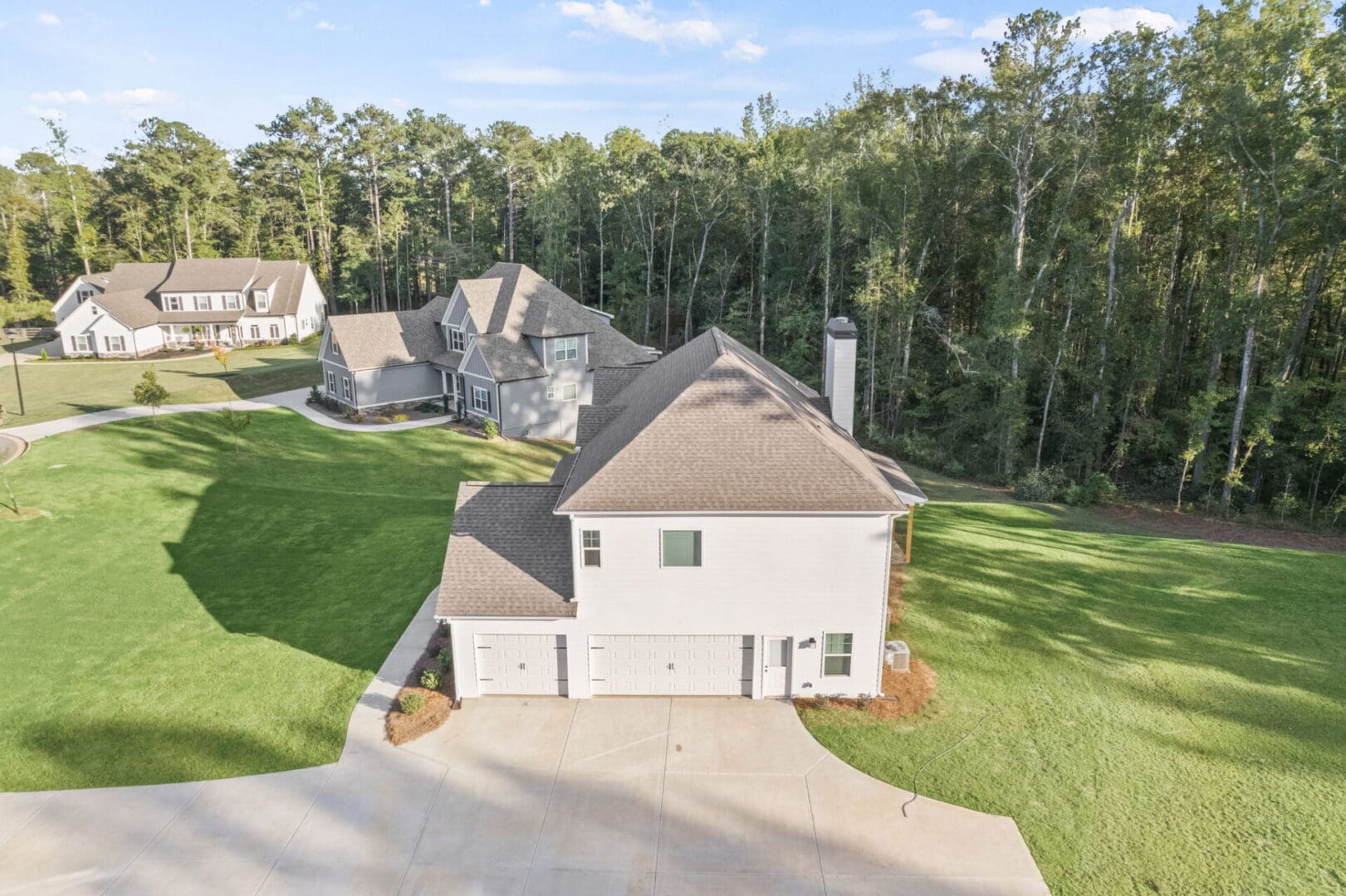 Aerial view of white house with three-car garage.