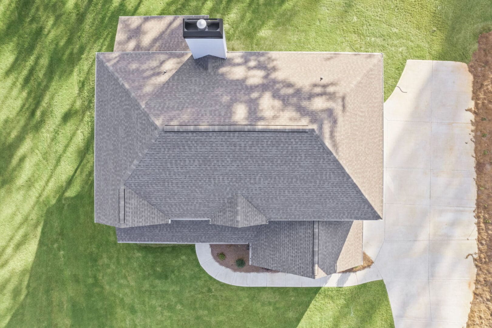 Aerial view of house with gray roof.