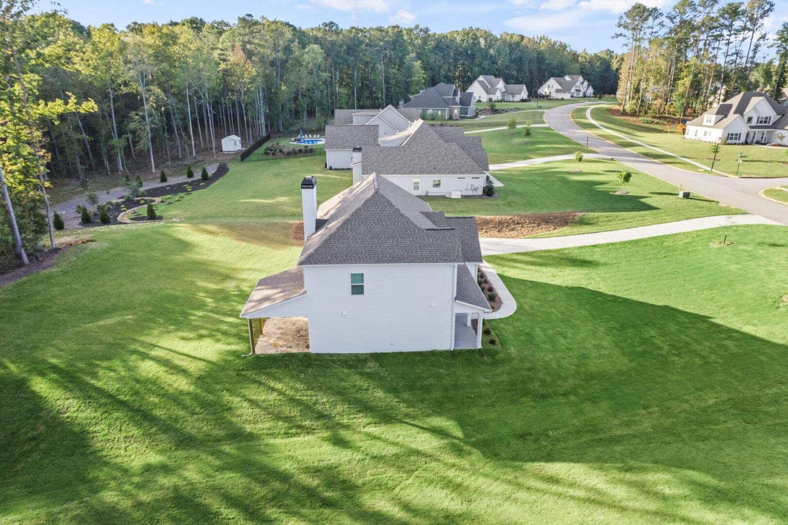 Aerial view of white house, green lawn.