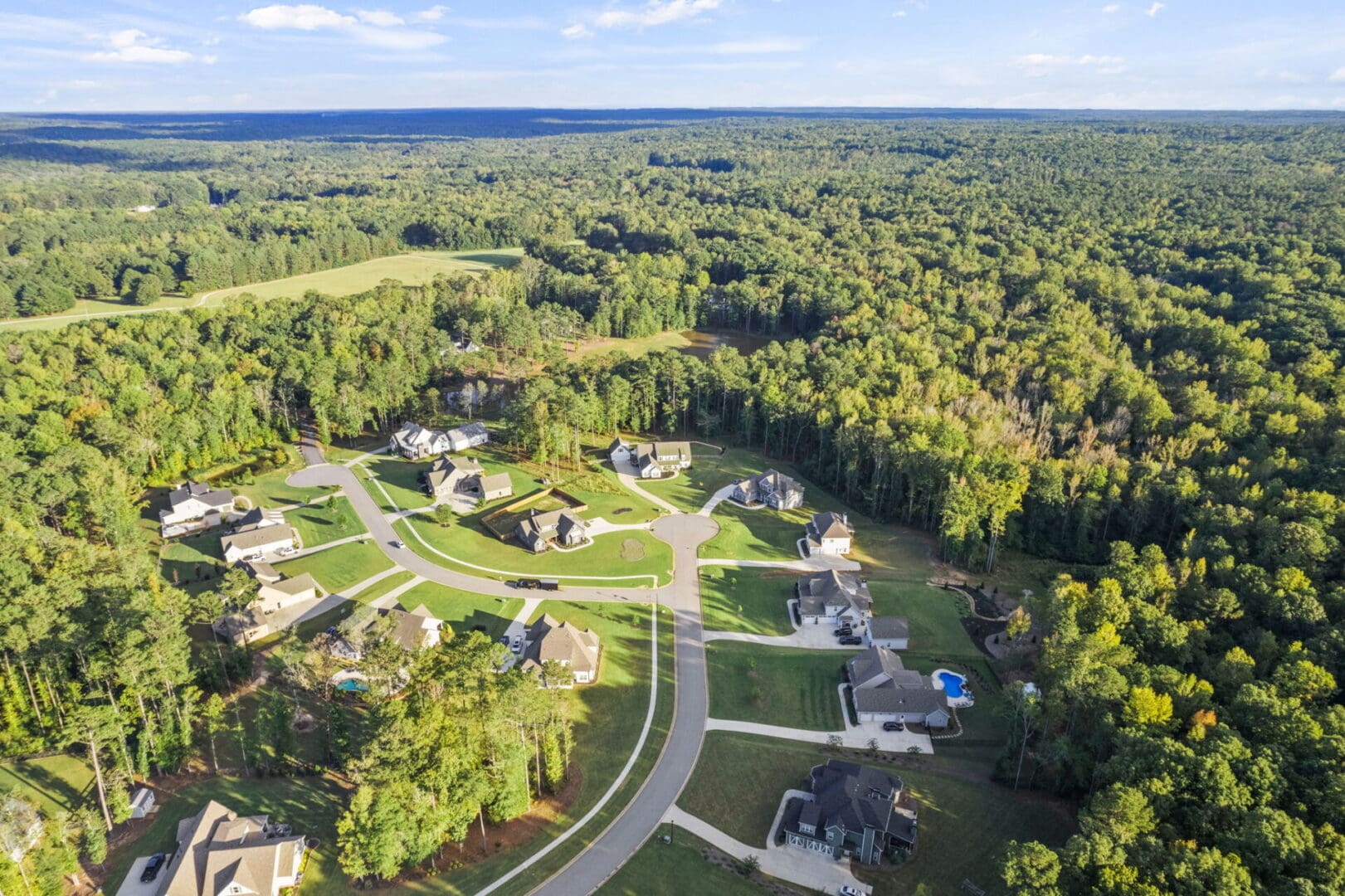 Aerial view of houses in wooded area.